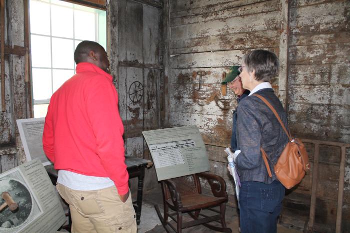 Sociology graduate student Kyle Chandler giving tour to visitors at the Craft House quarters in Holly Springs